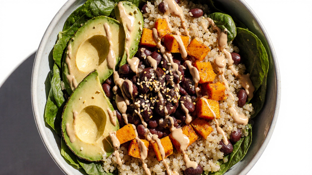 Colorful vegetarian grain bowl with black beans, sweet potato, quinoa, avocado, and spinach.